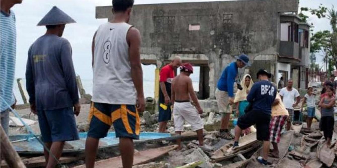 Fisherfolk assess boat damage in San Jose, Leyte. Credit: Oxfam